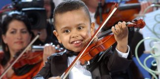 Surpriza e trevjeçarit/ Ngjitet “pa leje” në skenë dhe mahnit pjesëmarrësit me talentin në violinë (VIDEO)