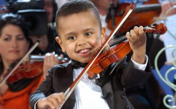 Surpriza e trevjeçarit/ Ngjitet “pa leje” në skenë dhe mahnit pjesëmarrësit me talentin në violinë (VIDEO)